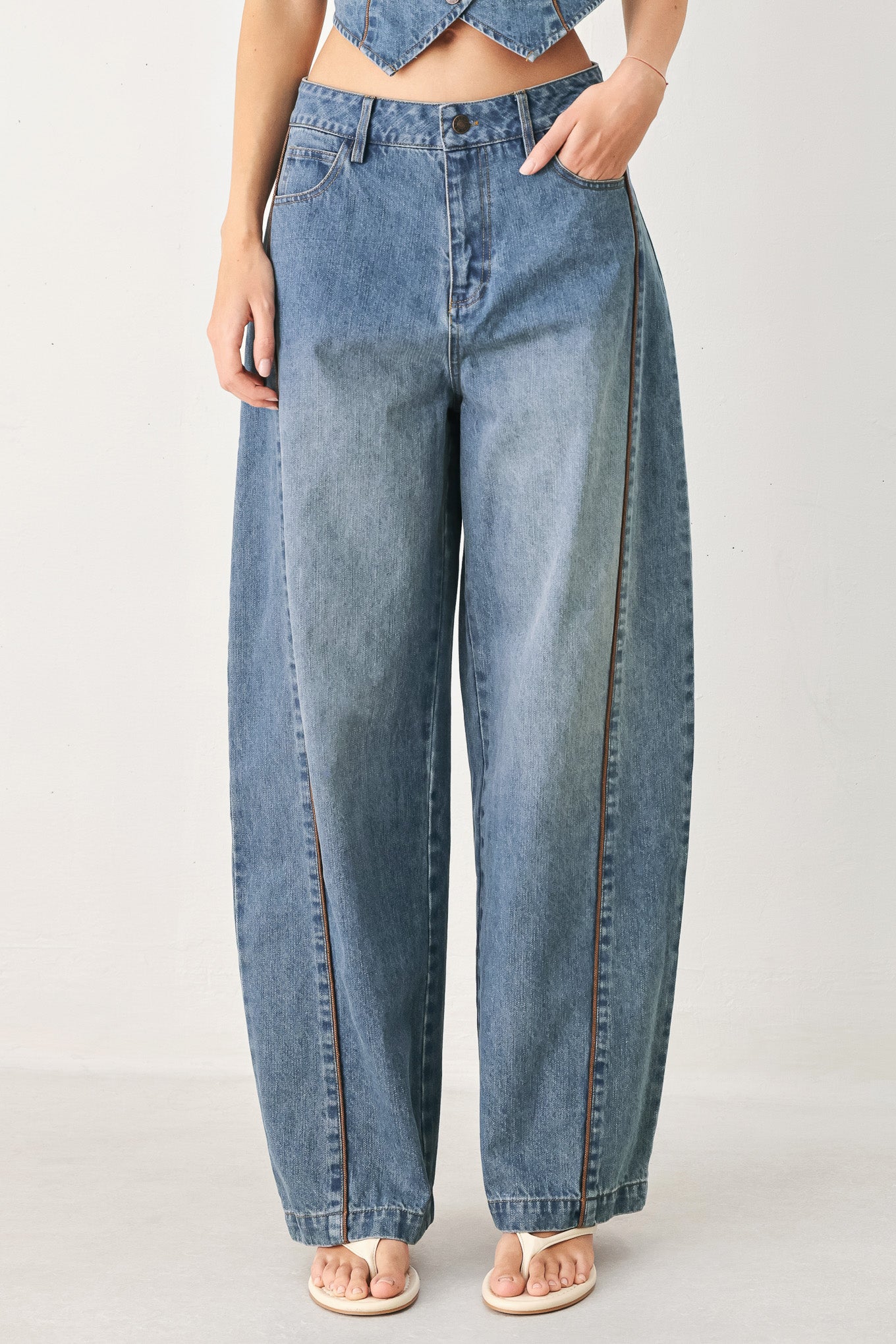 Person wearing light blue jeans on a plain background