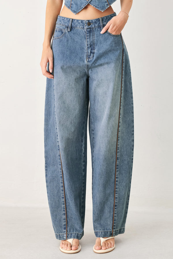 Woman wearing light blue denim balloon pant with front closure, pockets and piping detail | FREEMARKET