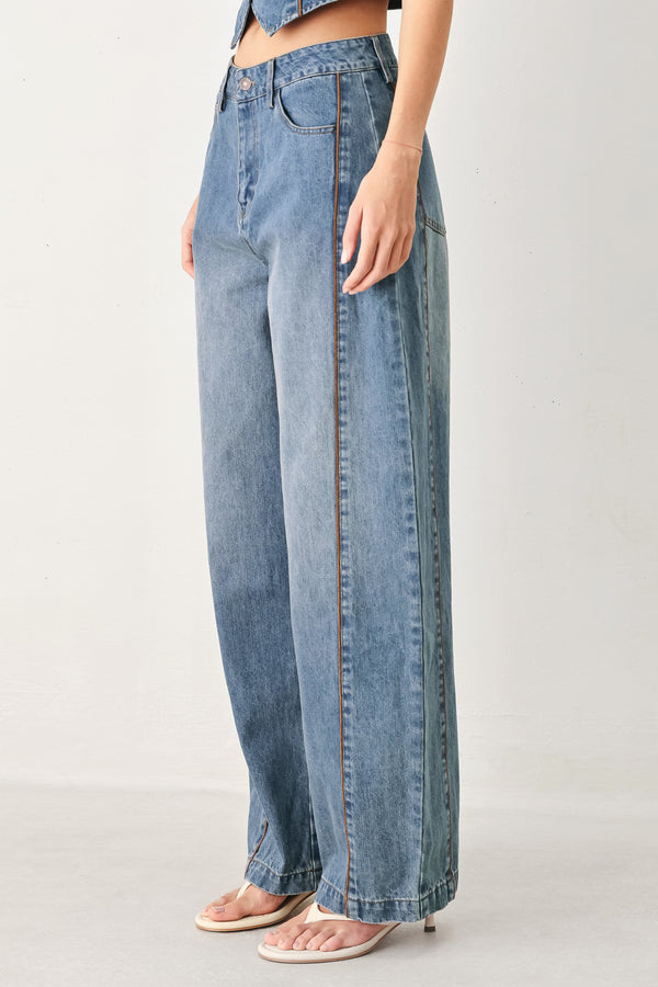 Woman wearing light blue denim balloon pant with front closure, pockets and piping detail | FREEMARKET