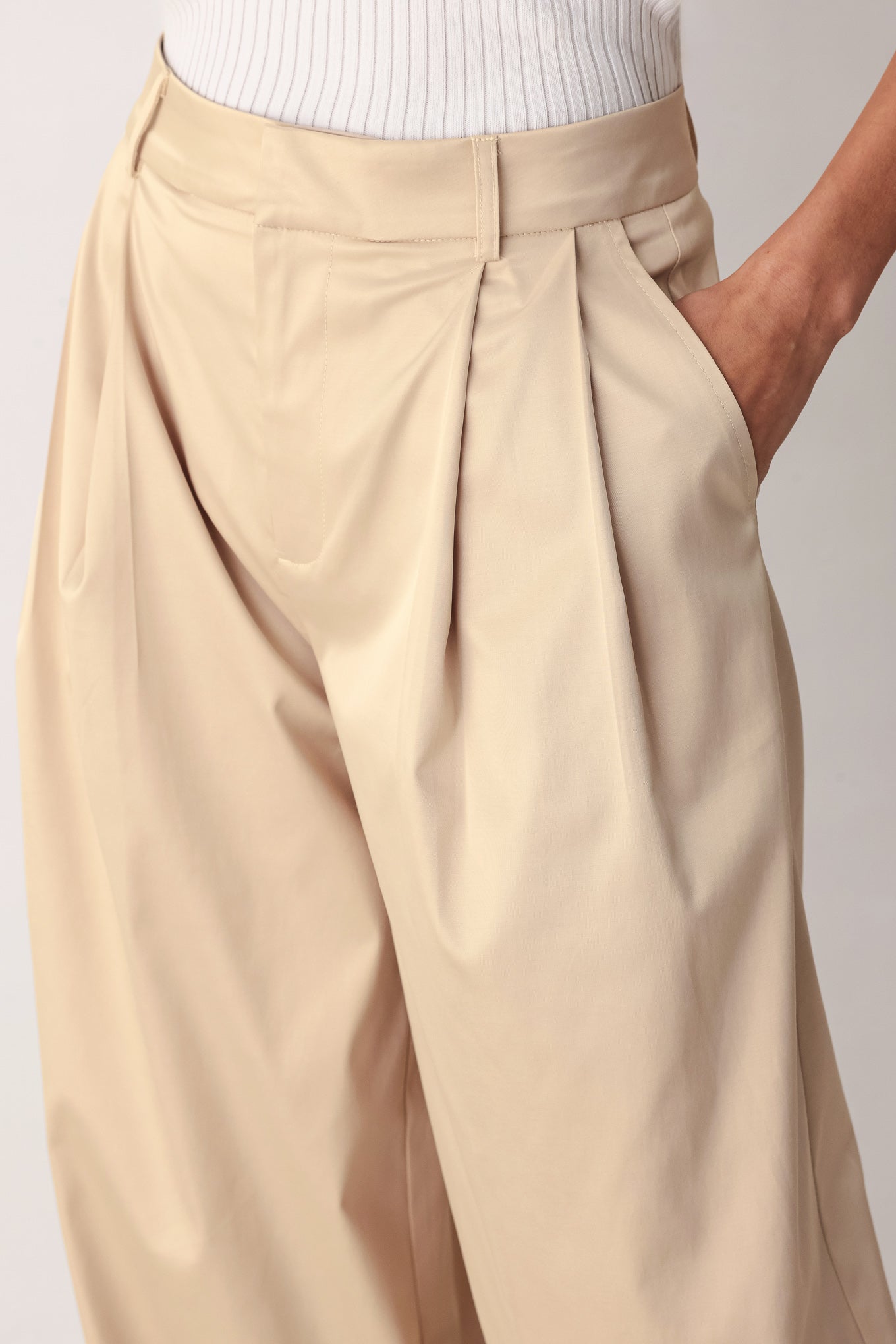 A person wearing high-waisted, wide-leg champagne trousers with a glossy finish | FREEMARKET