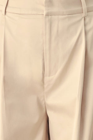 A person wearing high-waisted, wide-leg champagne trousers with a glossy finish | FREEMARKET
