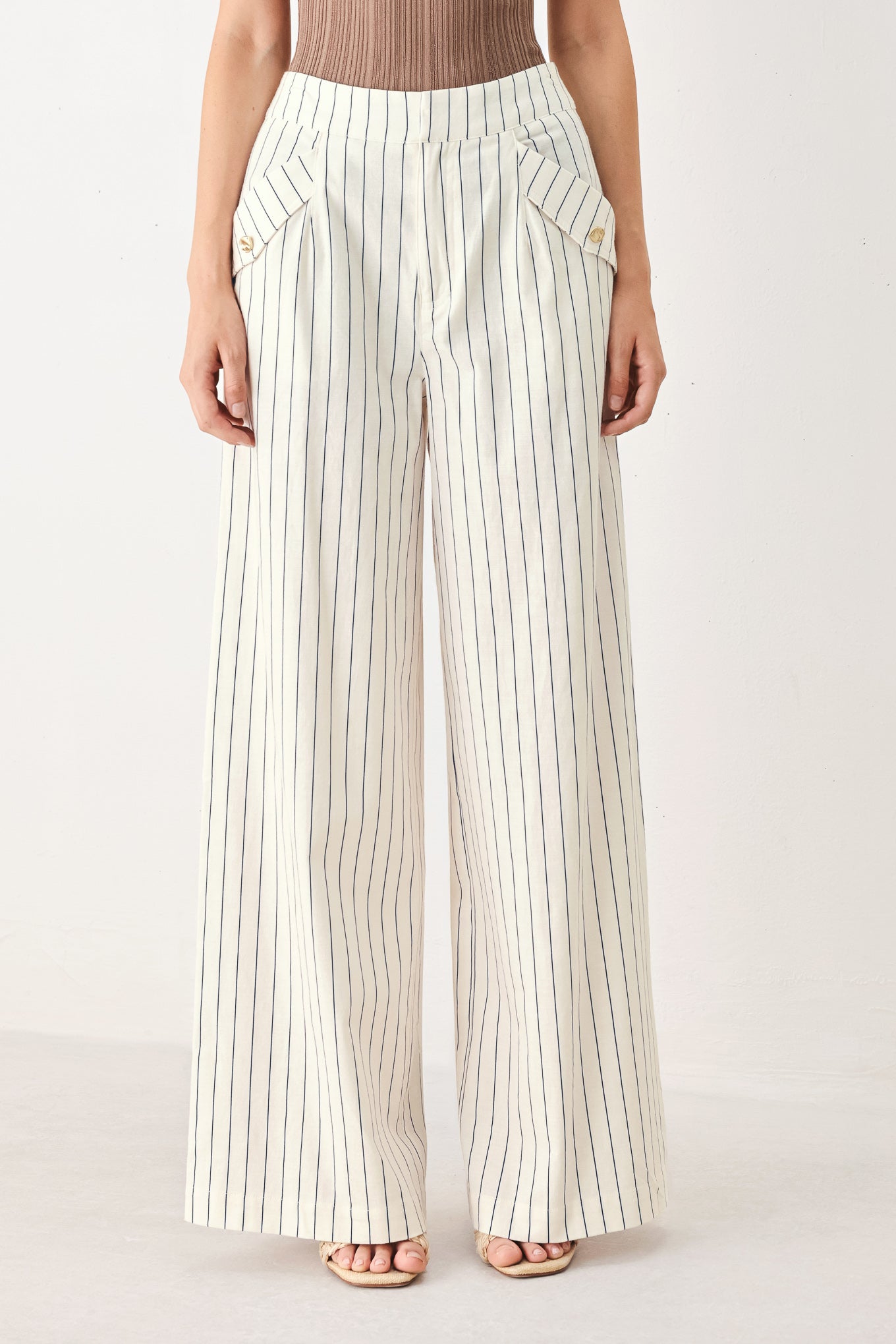 Woman wearing off white pants with thin navy stripes and front pockets | FREEMARKET