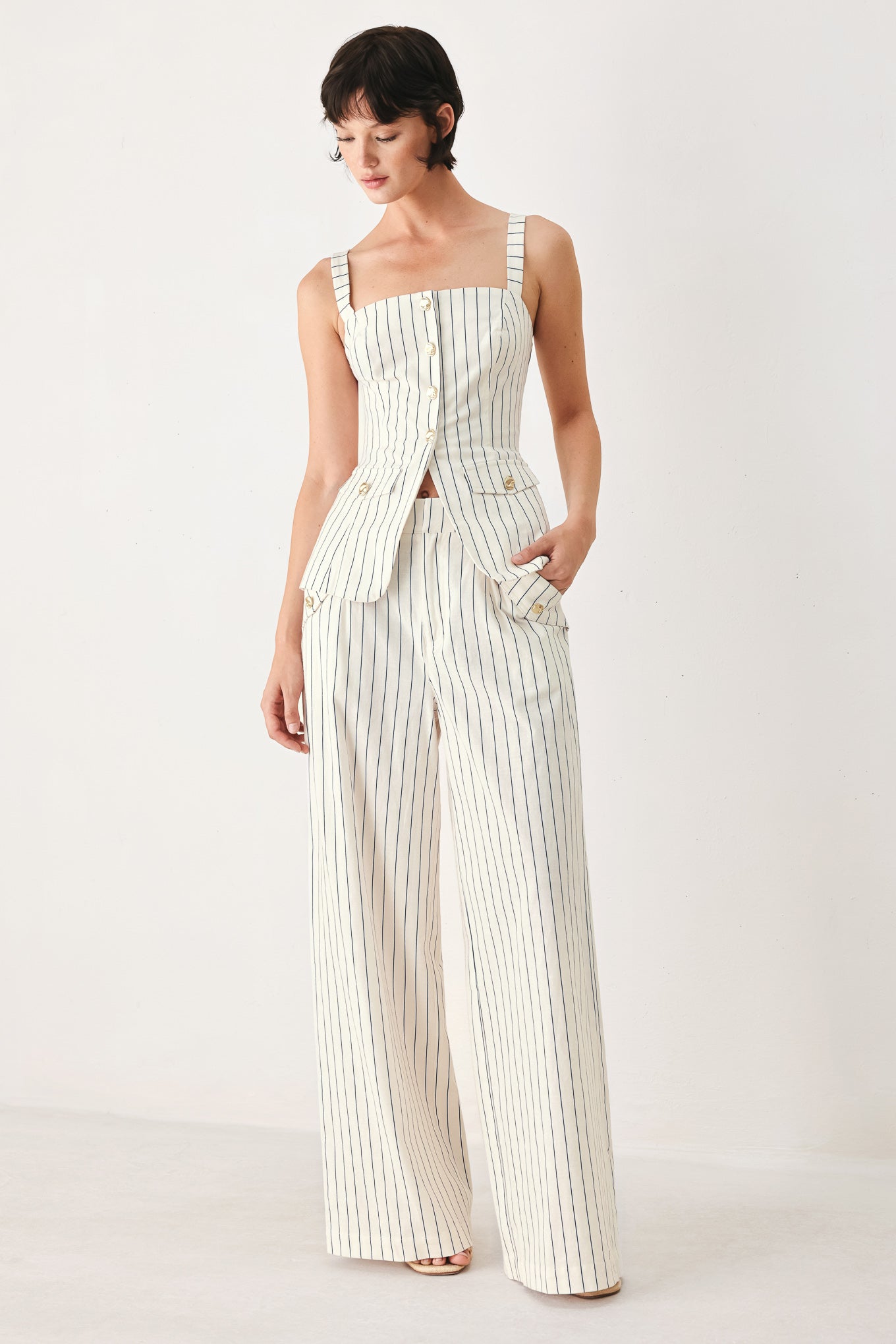 Woman wearing off white pants with thin navy stripes and front pockets | FREEMARKET
