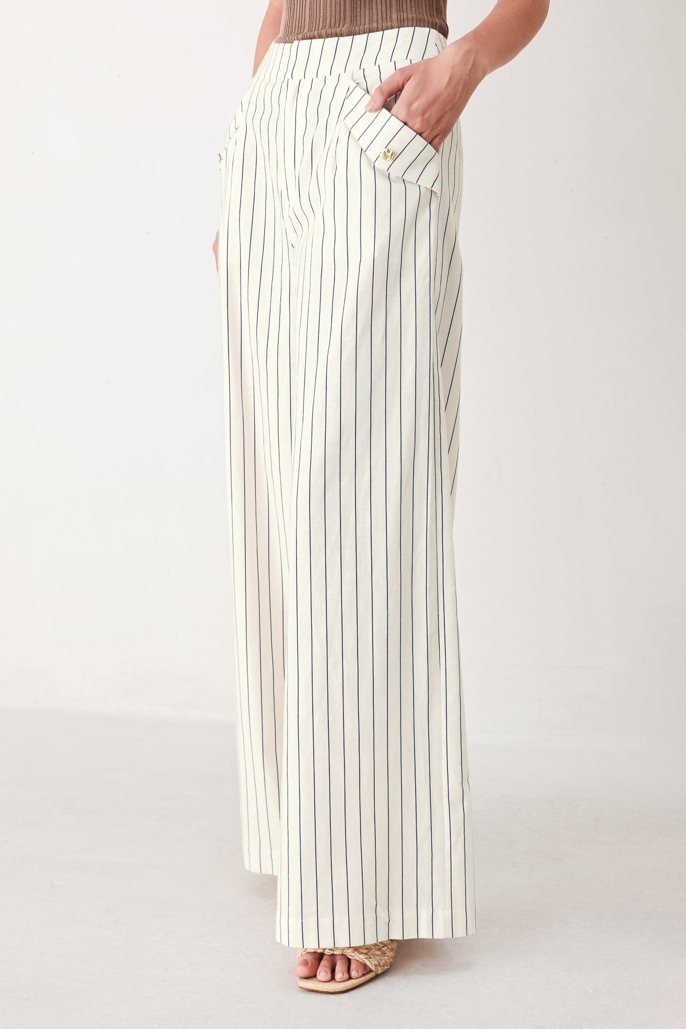 Woman wearing off white pants with thin navy stripes and front pockets | FREEMARKET