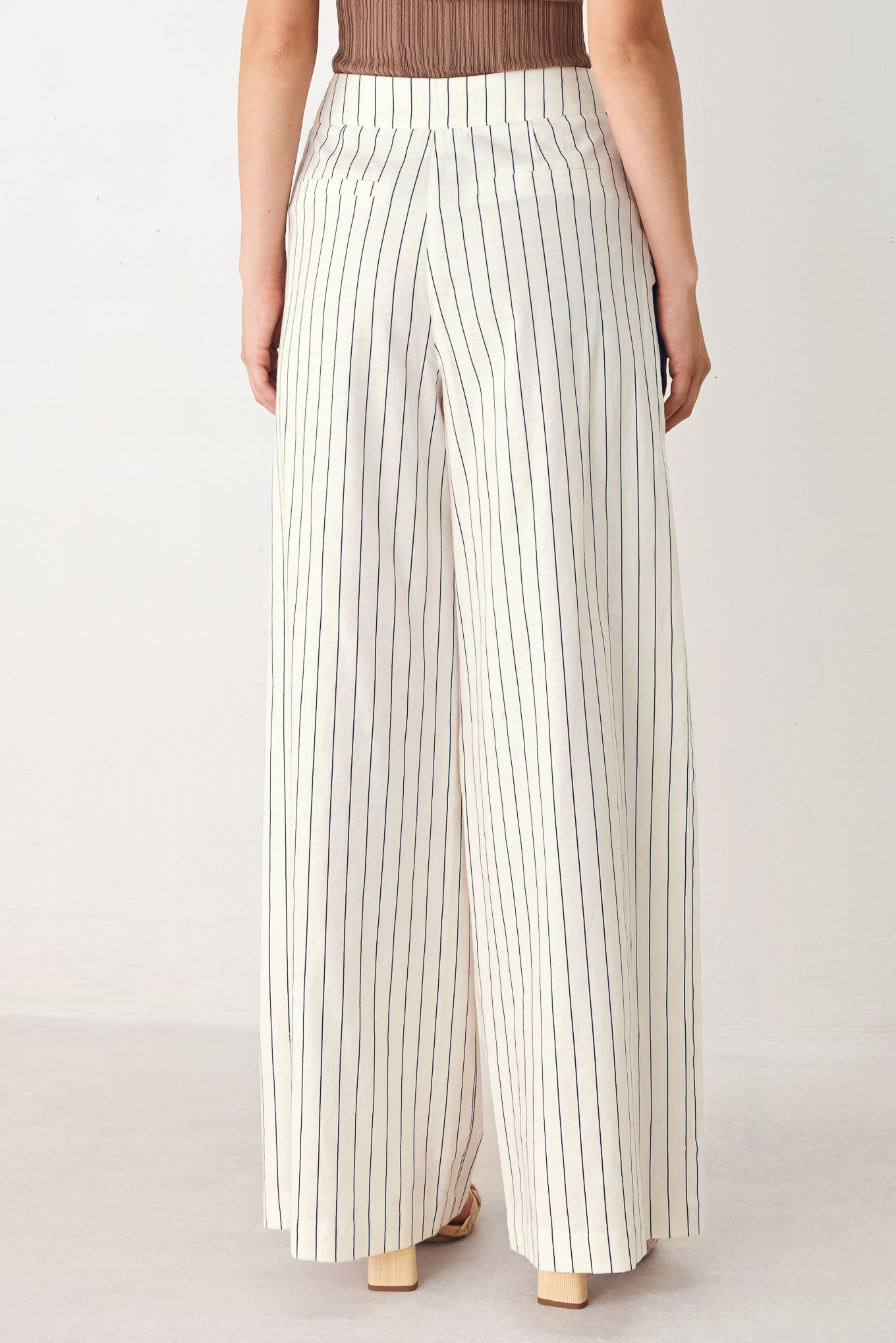 Woman wearing off white pants with thin navy stripes and front pockets | FREEMARKET