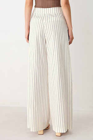 Woman wearing off white pants with thin navy stripes and front pockets | FREEMARKET