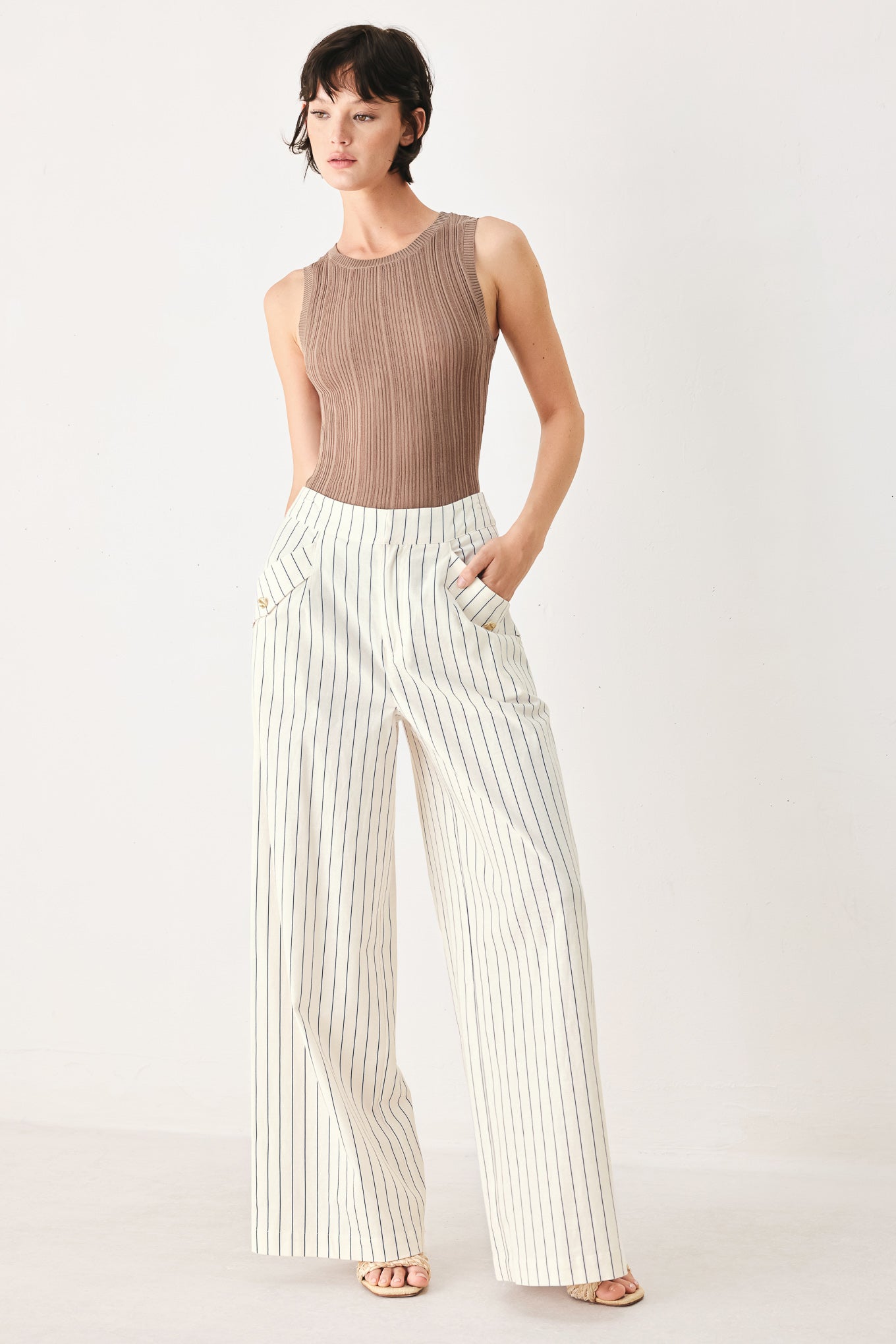 Woman wearing off white pants with thin navy stripes and front pockets | FREEMARKET