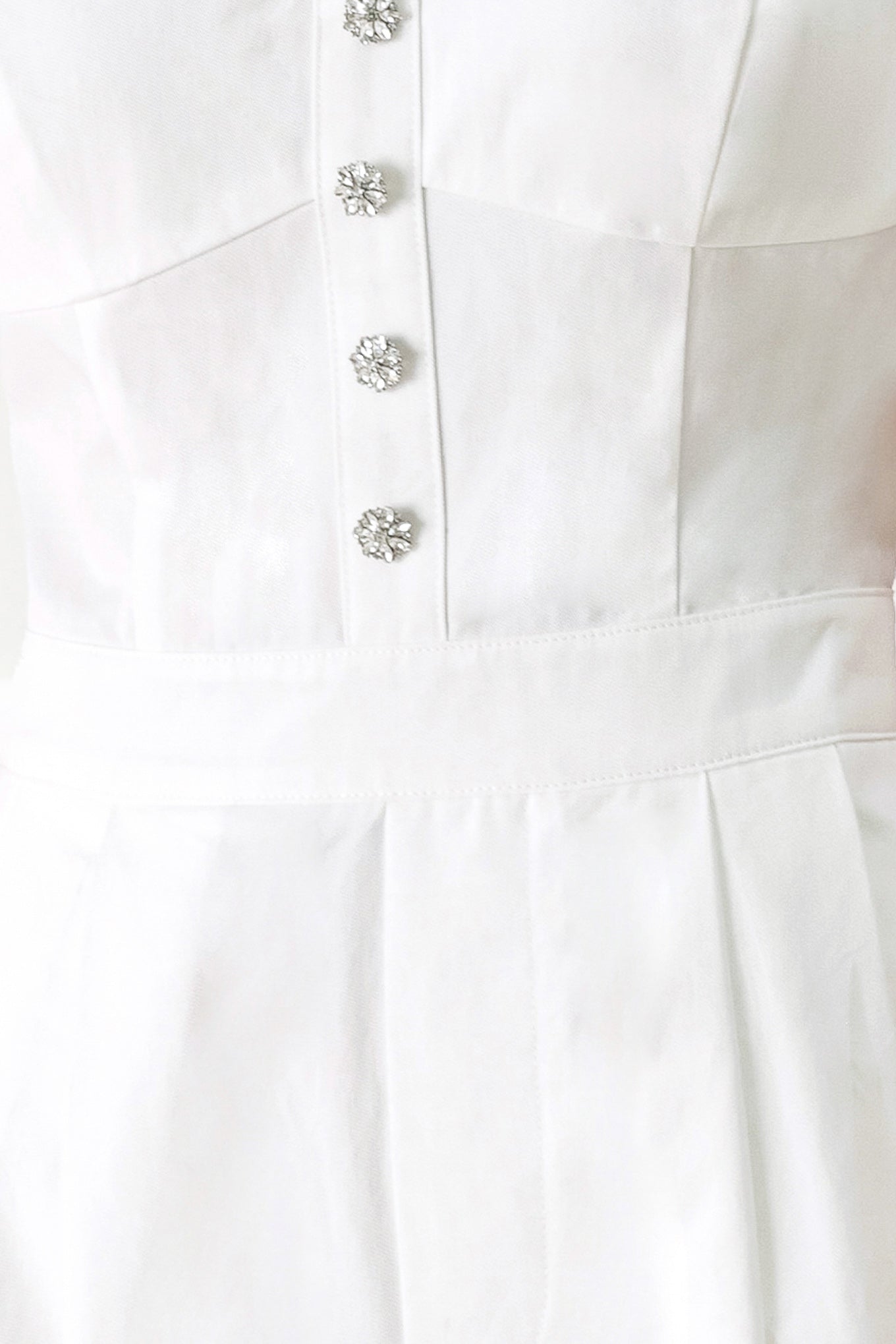 Woman wearing a white jumpsuit with front button detail, straps, side pockets, wide leg and back zipper closure | FREEMARKET
