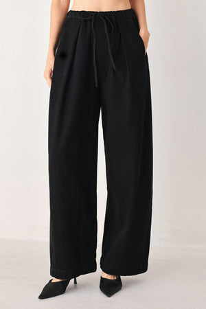 Woman wearing black wide-leg drawstring pants | FREEMARKET