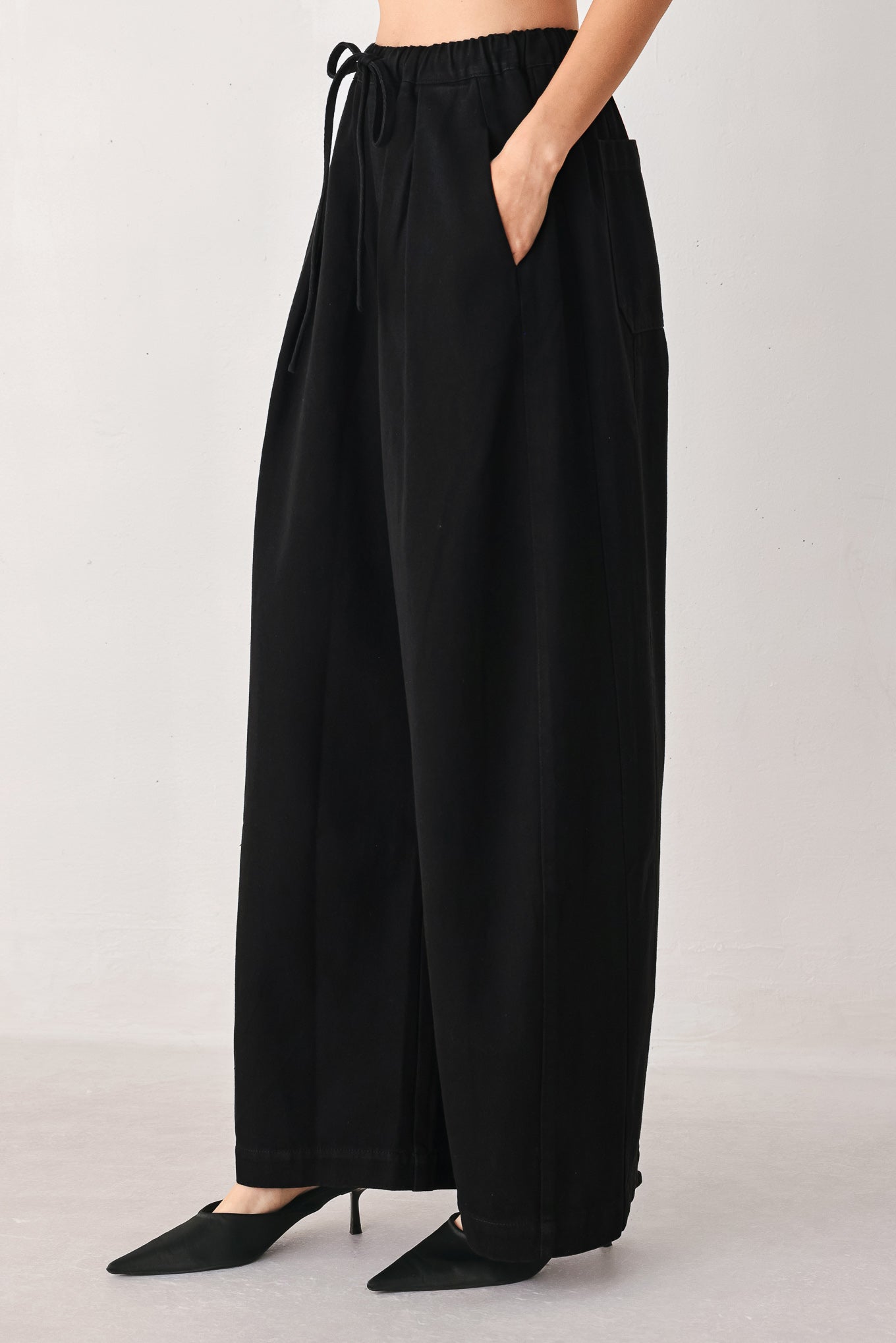 Woman wearing black wide-leg drawstring pants | FREEMARKET