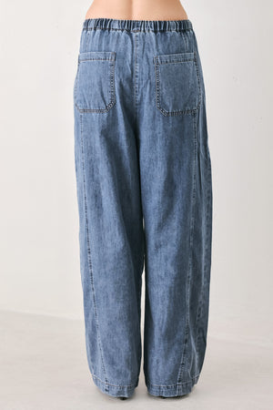 A person wearing wide-leg blue denim drawstring pants with a relaxed, oversized fit | FREEMARKET