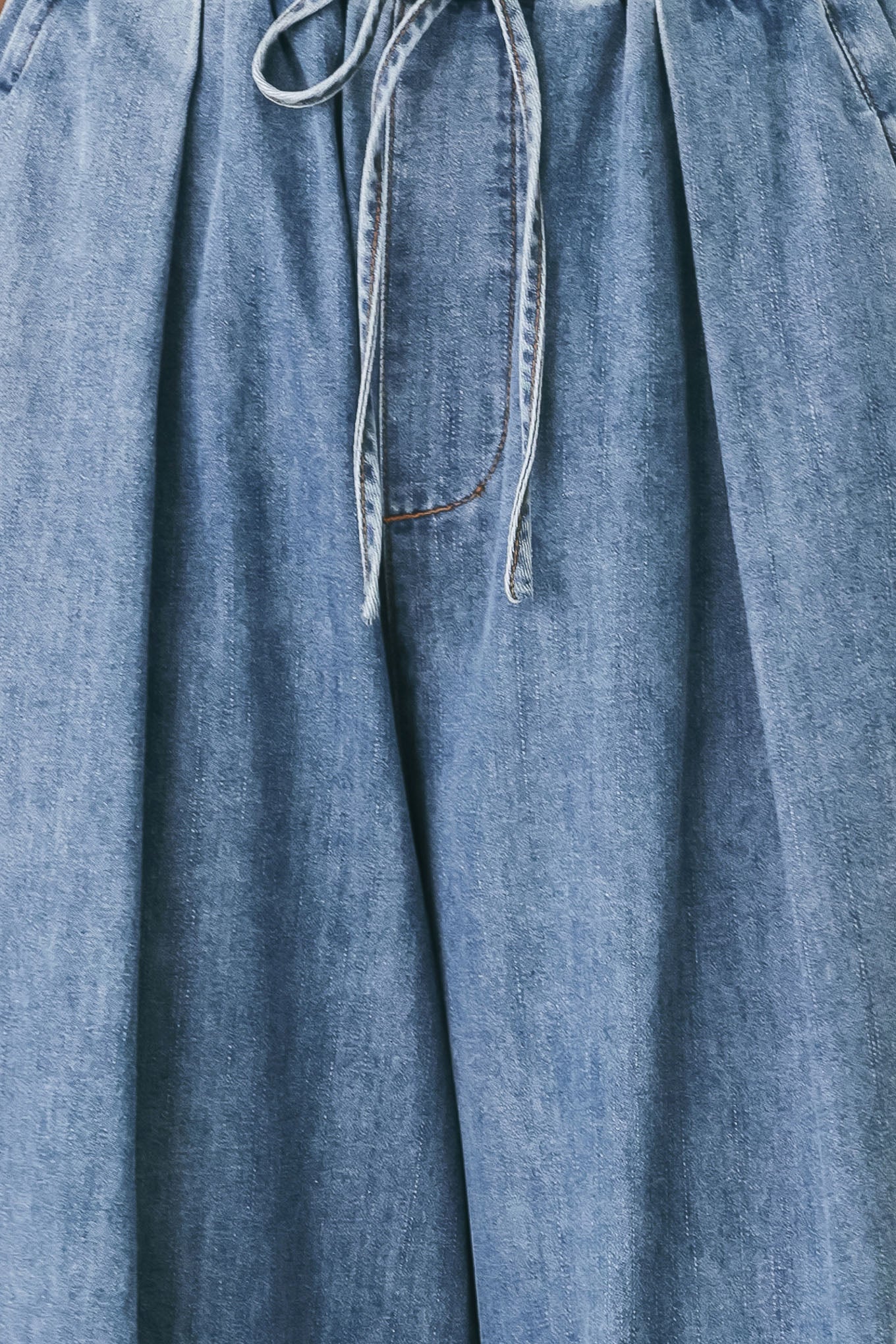 Woman wearing blue denim wide-leg pants with pockets and elastic waist with tie | FREEMARKET