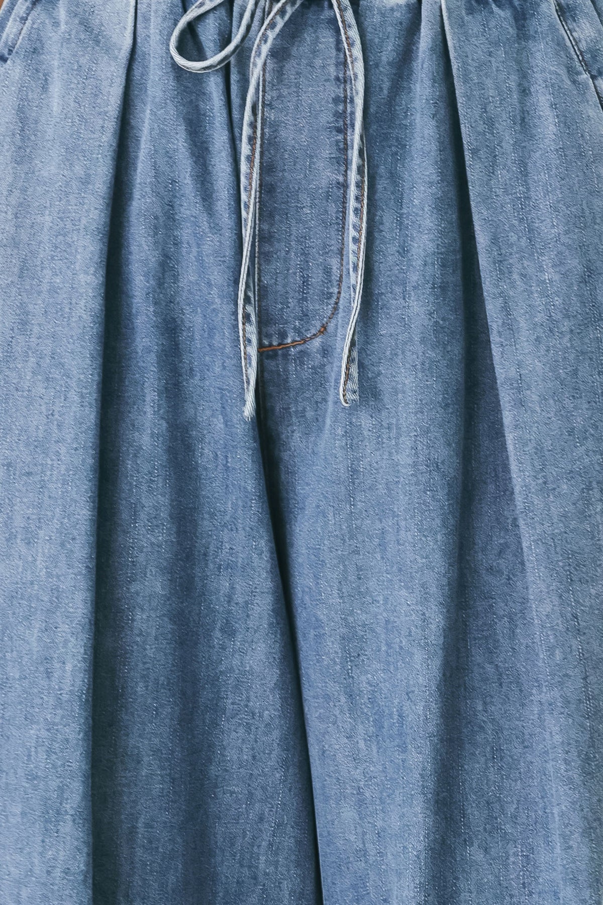 A person wearing wide-leg blue denim drawstring pants with a relaxed, oversized fit | FREEMARKET