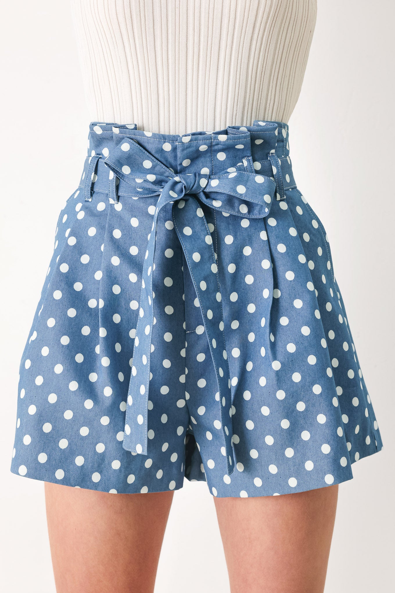 Woman wearing blue polka dot shorts featuring paper bag waist, self waist tie, side pockets and front closure | FREEMARKET