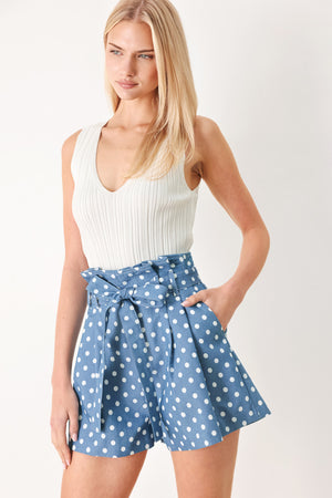Woman wearing blue polka dot shorts featuring paper bag waist, self waist tie, side pockets and front closure | FREEMARKET
