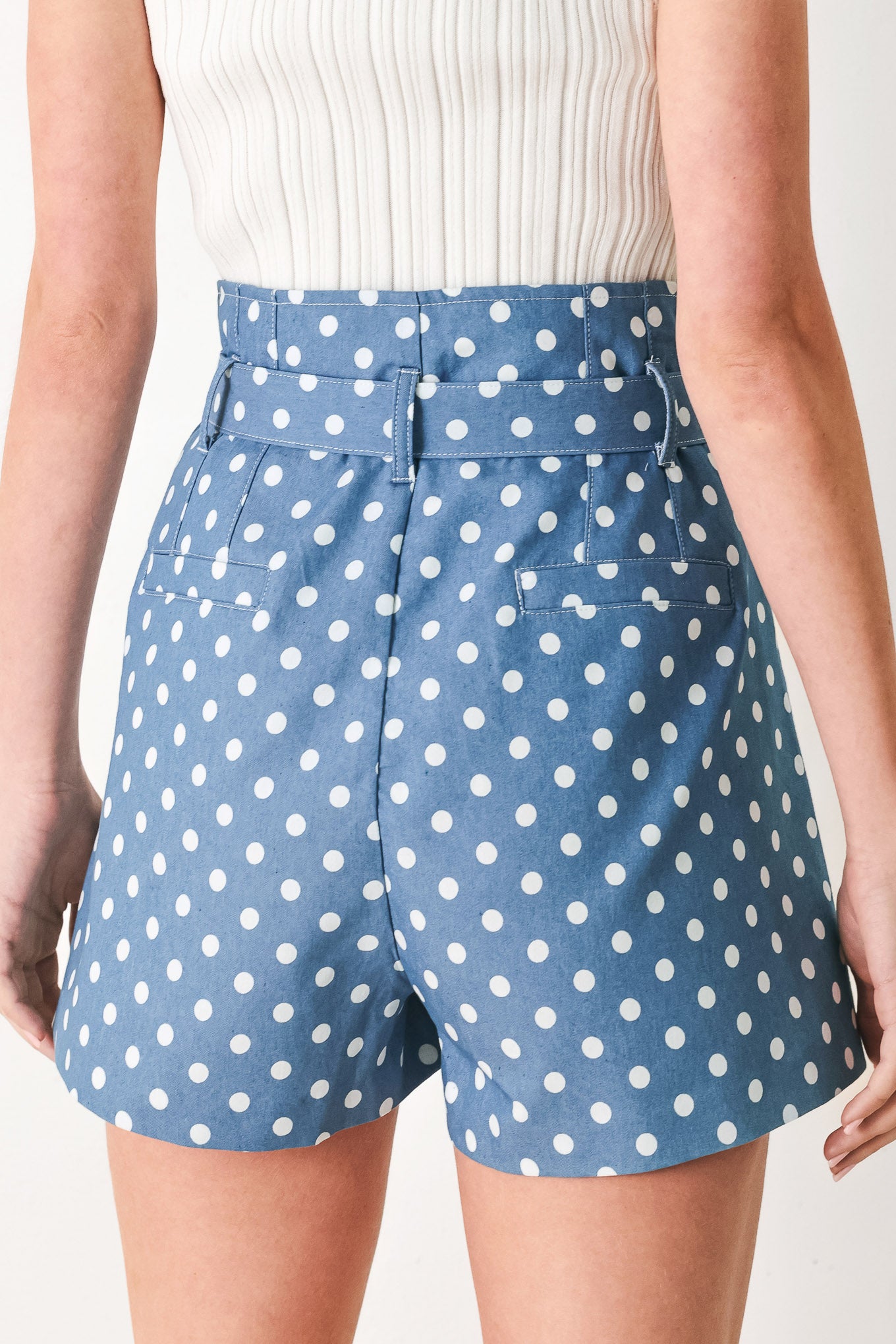 Woman wearing blue polka dot shorts featuring paper bag waist, self waist tie, side pockets and front closure | FREEMARKET