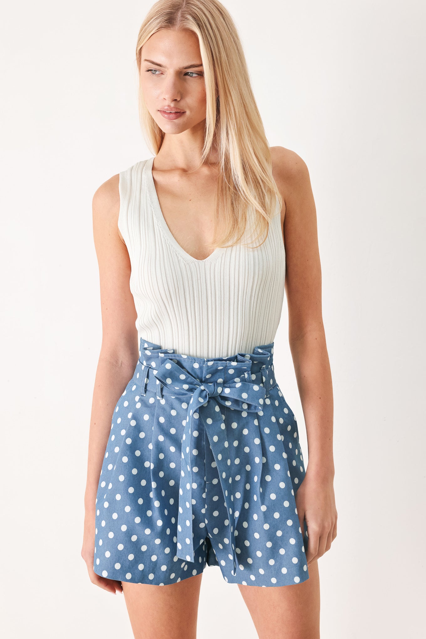 Woman wearing blue polka dot shorts featuring paper bag waist, self waist tie, side pockets and front closure | FREEMARKET