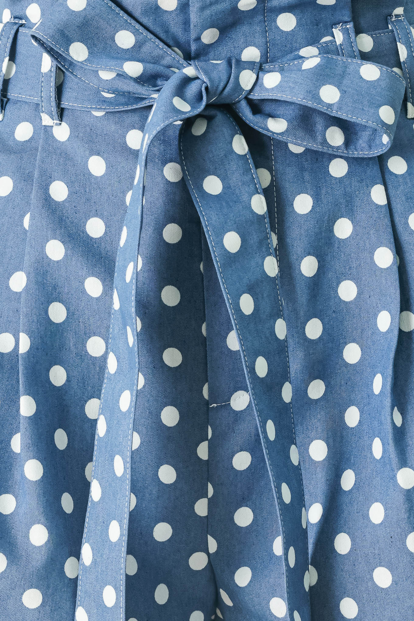 Close up of blue polka dot shorts featuring paper bag waist, self waist tie, side pockets and front closure | FREEMARKET
