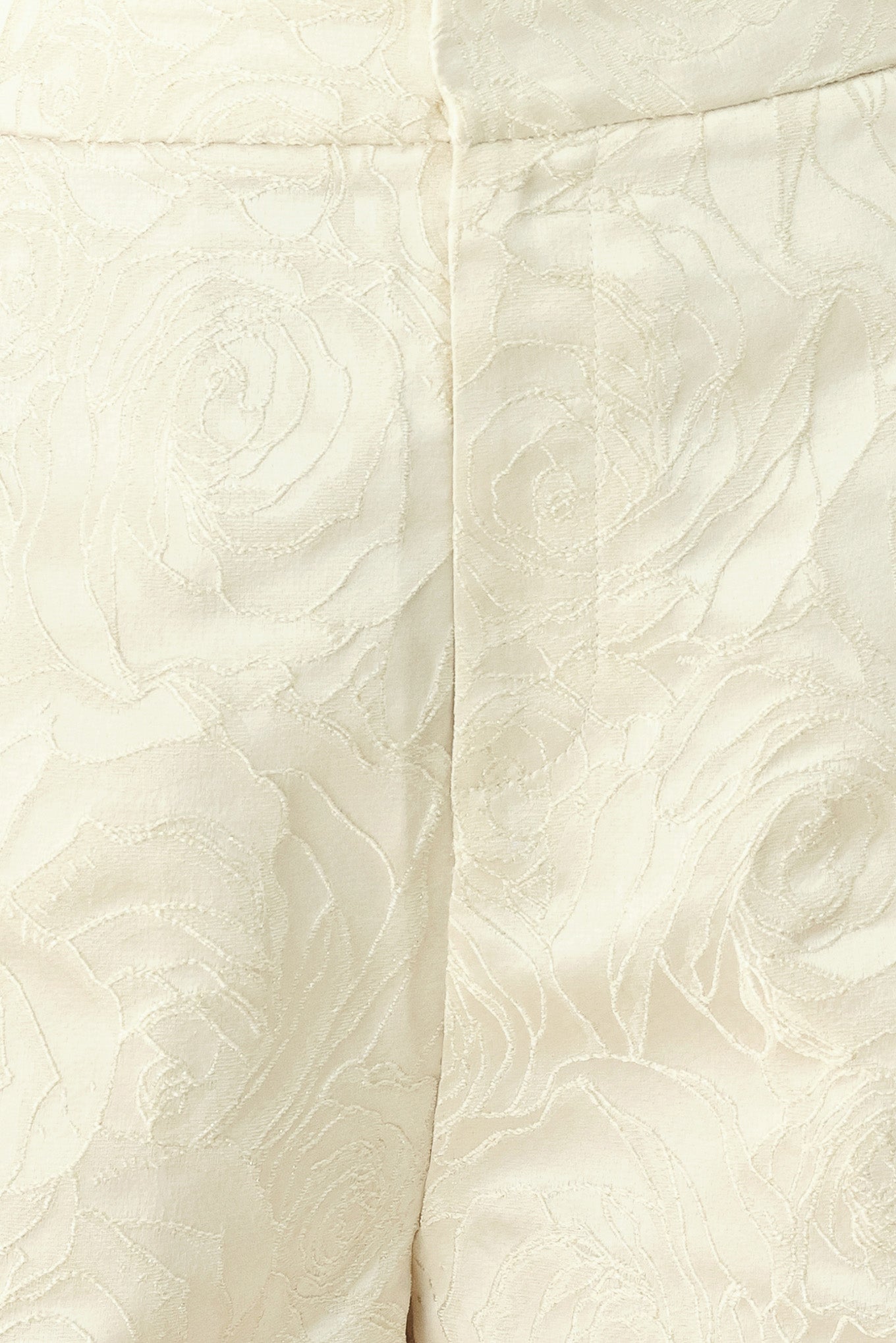 Woman wearing high-waisted cream shorts with a subtle embossed swirl pattern and decorative gold-tone buttons down the side pocket | FREEMARKET