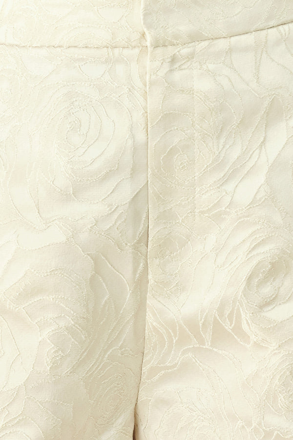Woman wearing high-waisted cream shorts with a subtle embossed swirl pattern and decorative gold-tone buttons down the side pocket | FREEMARKET