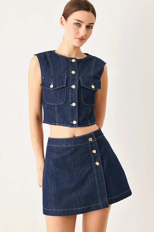 Woman wearing a blue denim  denim skort with front closure and button detail | FREEMARKET
