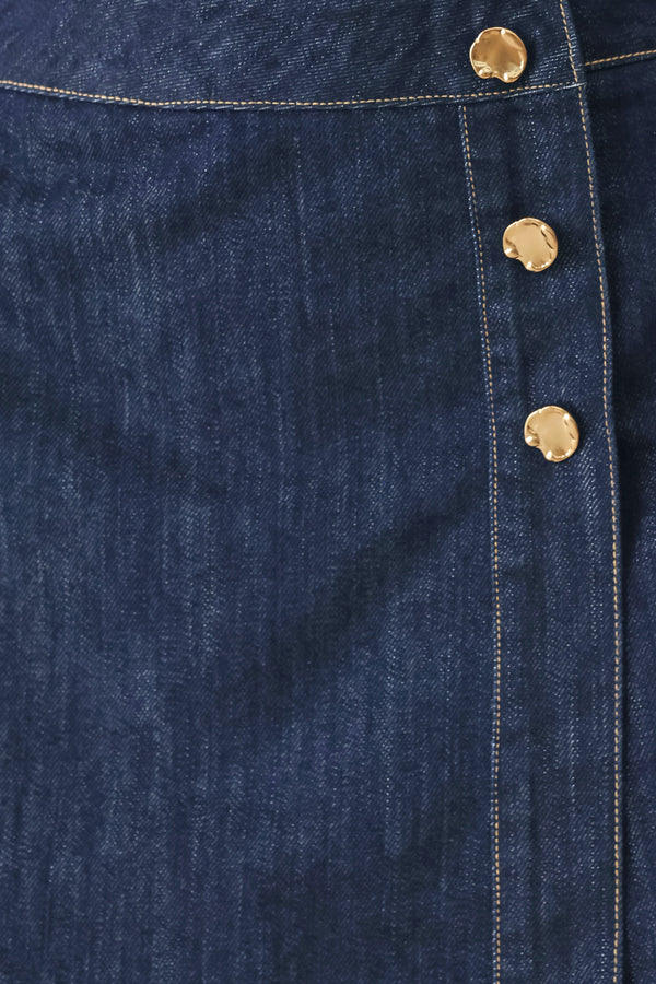 Woman wearing a blue denim  denim skort with front closure and button detail | FREEMARKET