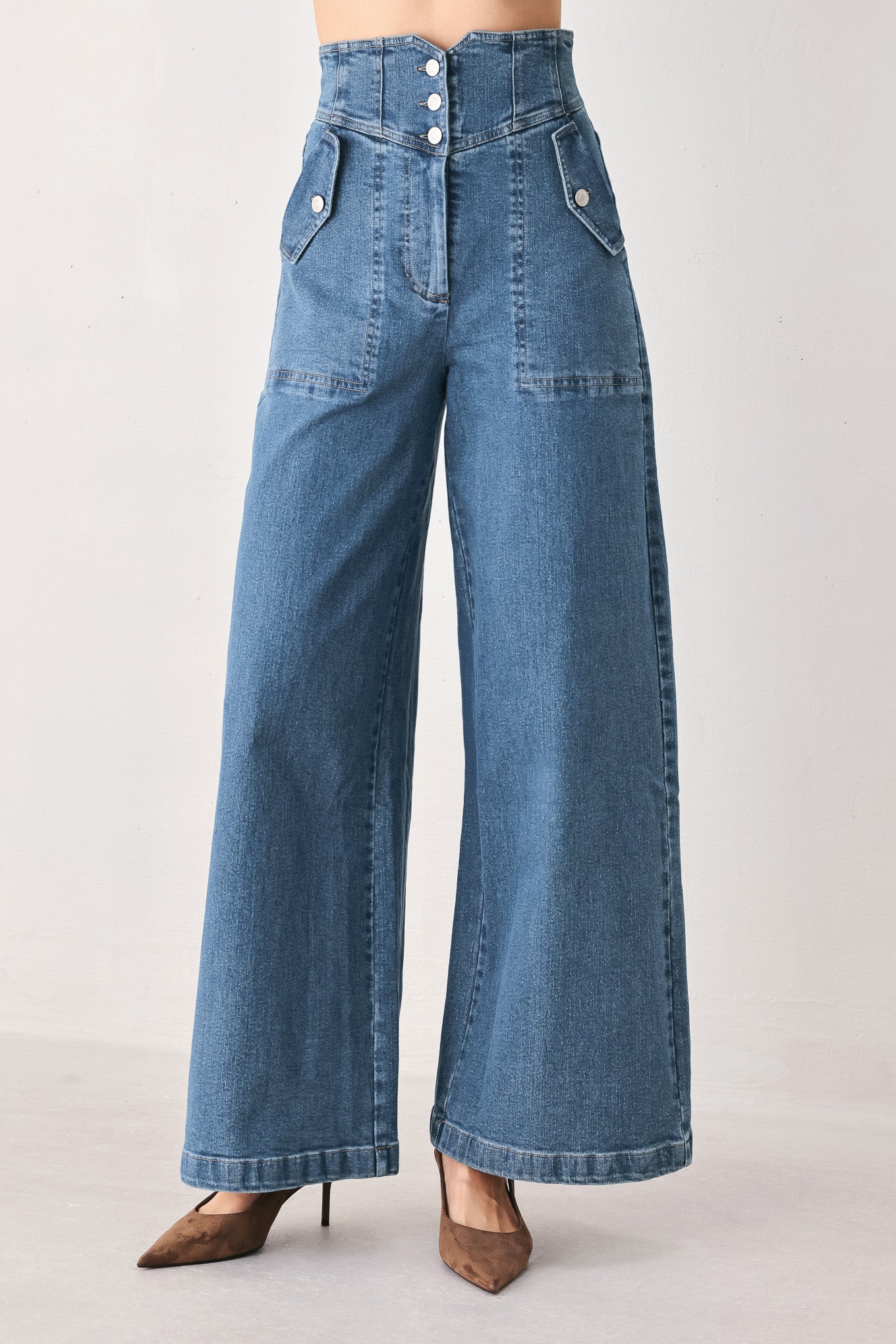 Woman wearing a pair of wide-leg blue denim jeans with a high waist, button fly, and decorative front pockets | FREEMARKET