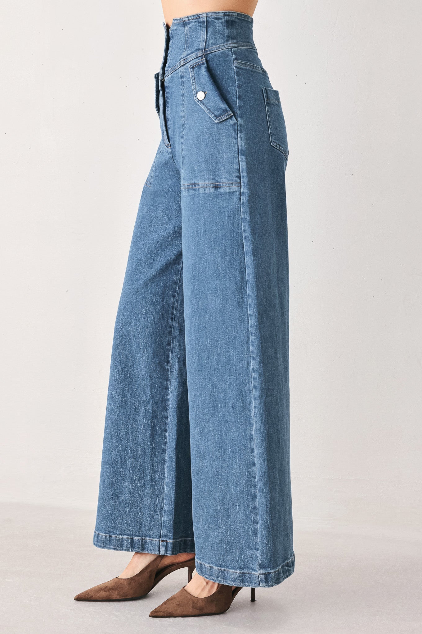 Woman wearing a pair of wide-leg blue denim jeans with a high waist, button fly, and decorative front pockets | FREEMARKET