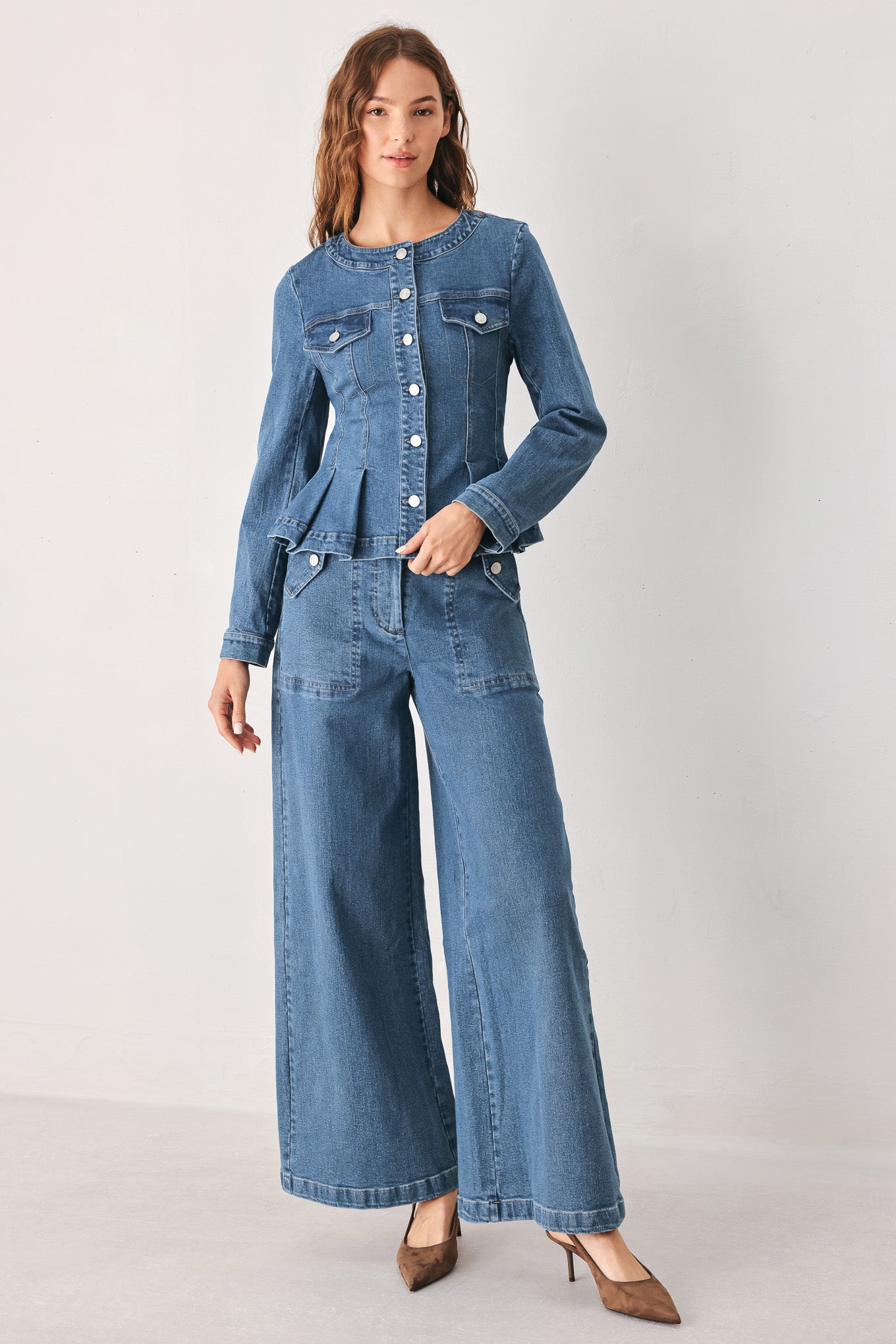 Woman wearing a pair of wide-leg blue denim jeans with a high waist, button fly, and decorative front pockets | FREEMARKET