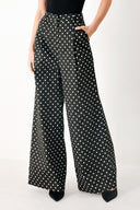 Woman wearing black polka dot pants with front closure, side pockets and wide leg | FREEMARKET