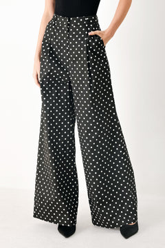 Woman wearing black polka dot pants with front closure, side pockets and wide leg | FREEMARKET