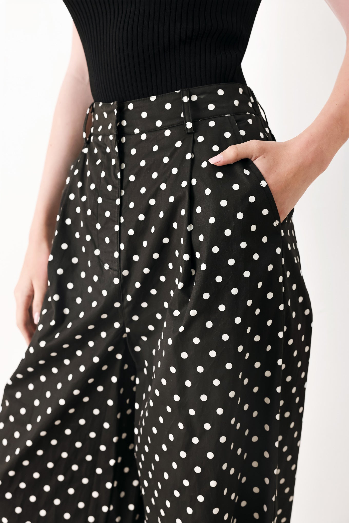 Woman wearing black polka dot pants with front closure, side pockets and wide leg | FREEMARKET