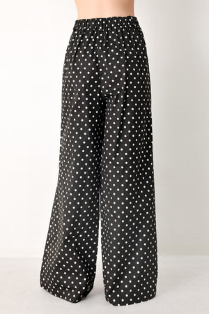 Woman wearing black polka dot pants with front closure, side pockets and wide leg | FREEMARKET