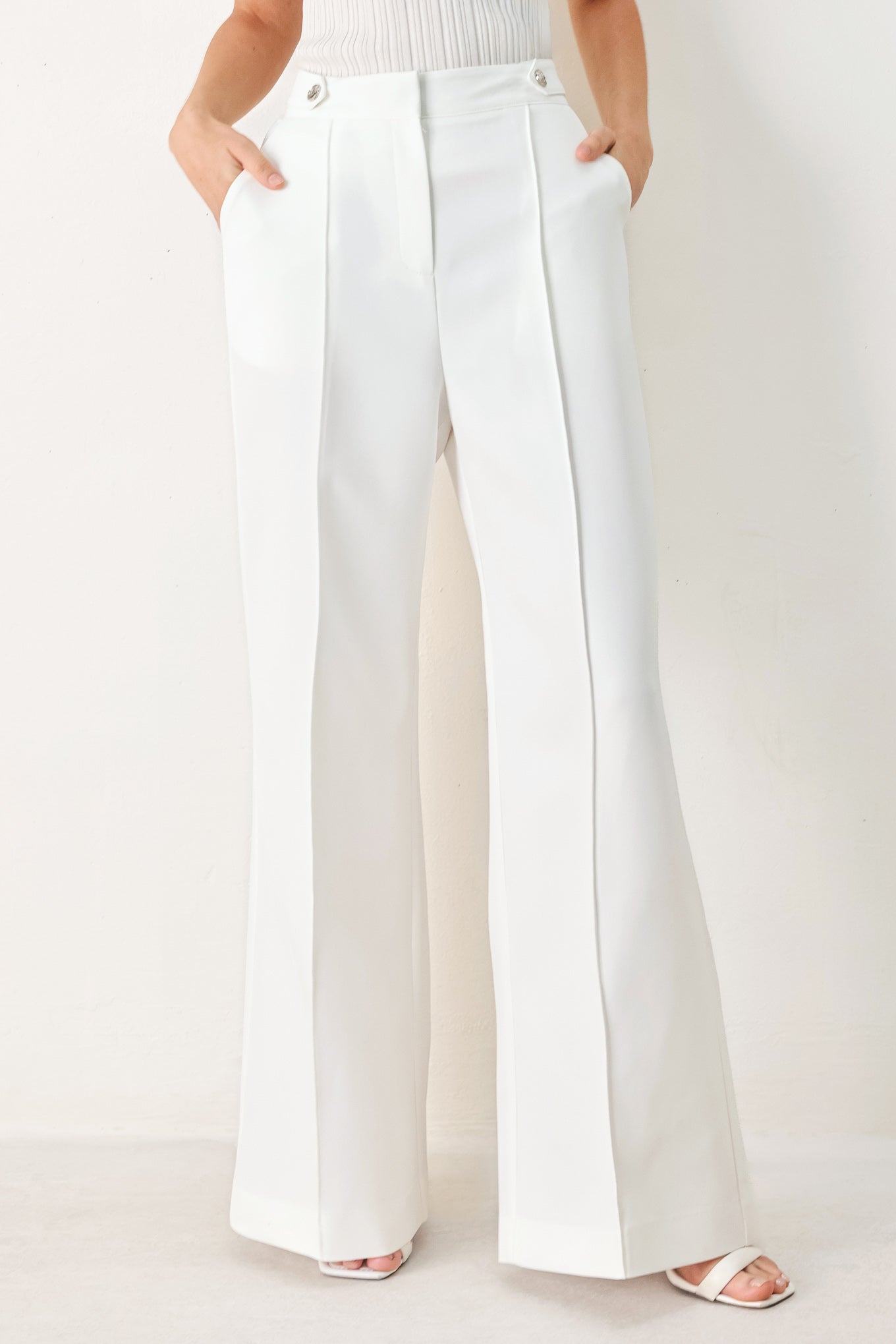 Woman wearing white wide-leg pants with side pockets and front closure | FREEMARKET