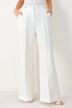Woman wearing white wide-leg pants with side pockets and front closure | FREEMARKET