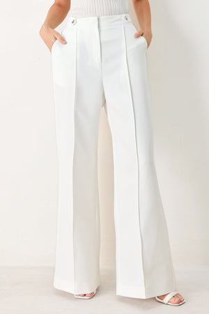 Woman wearing white wide-leg pants with side pockets and front closure | FREEMARKET