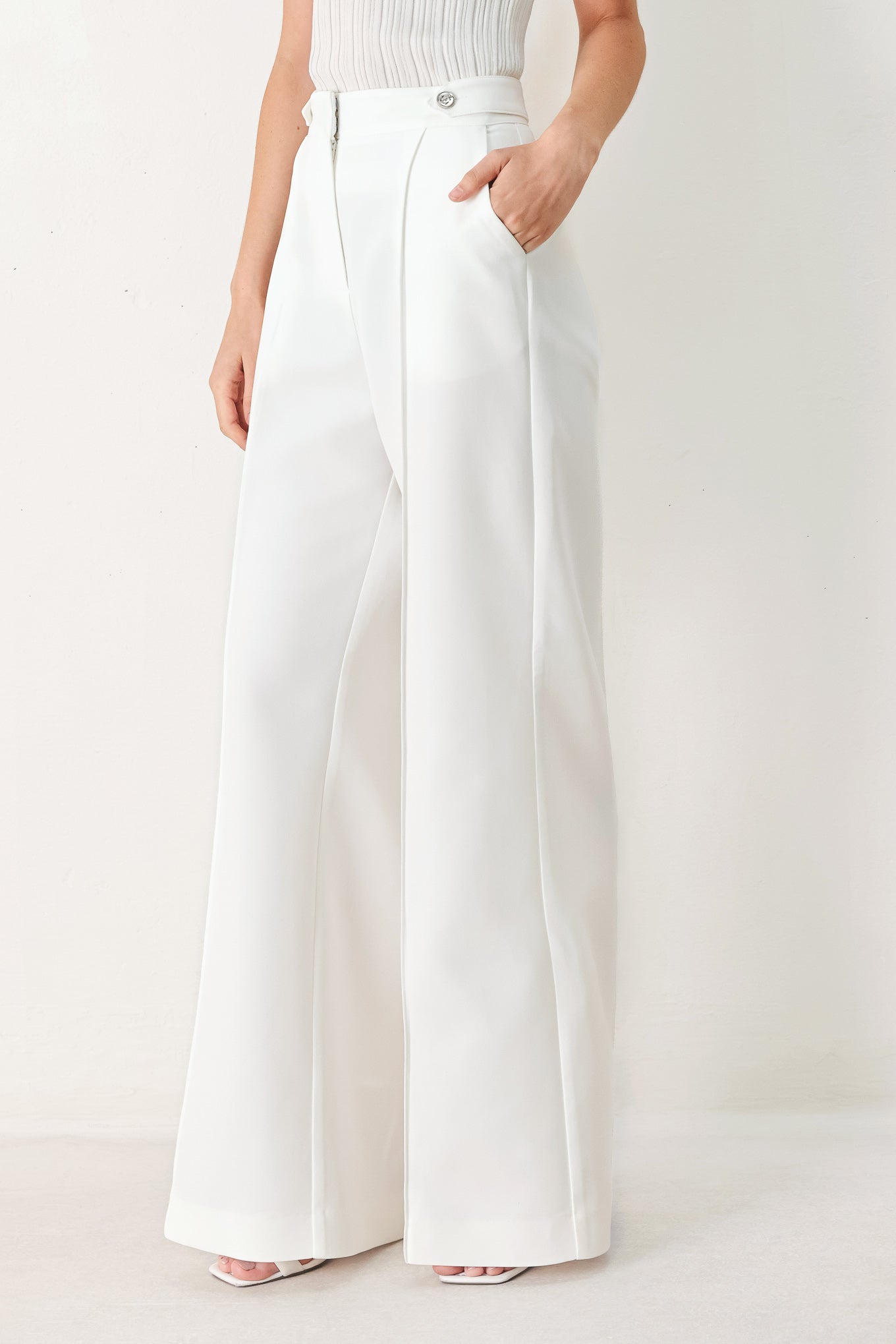 Woman wearing white wide-leg pants with side pockets and front closure | FREEMARKET