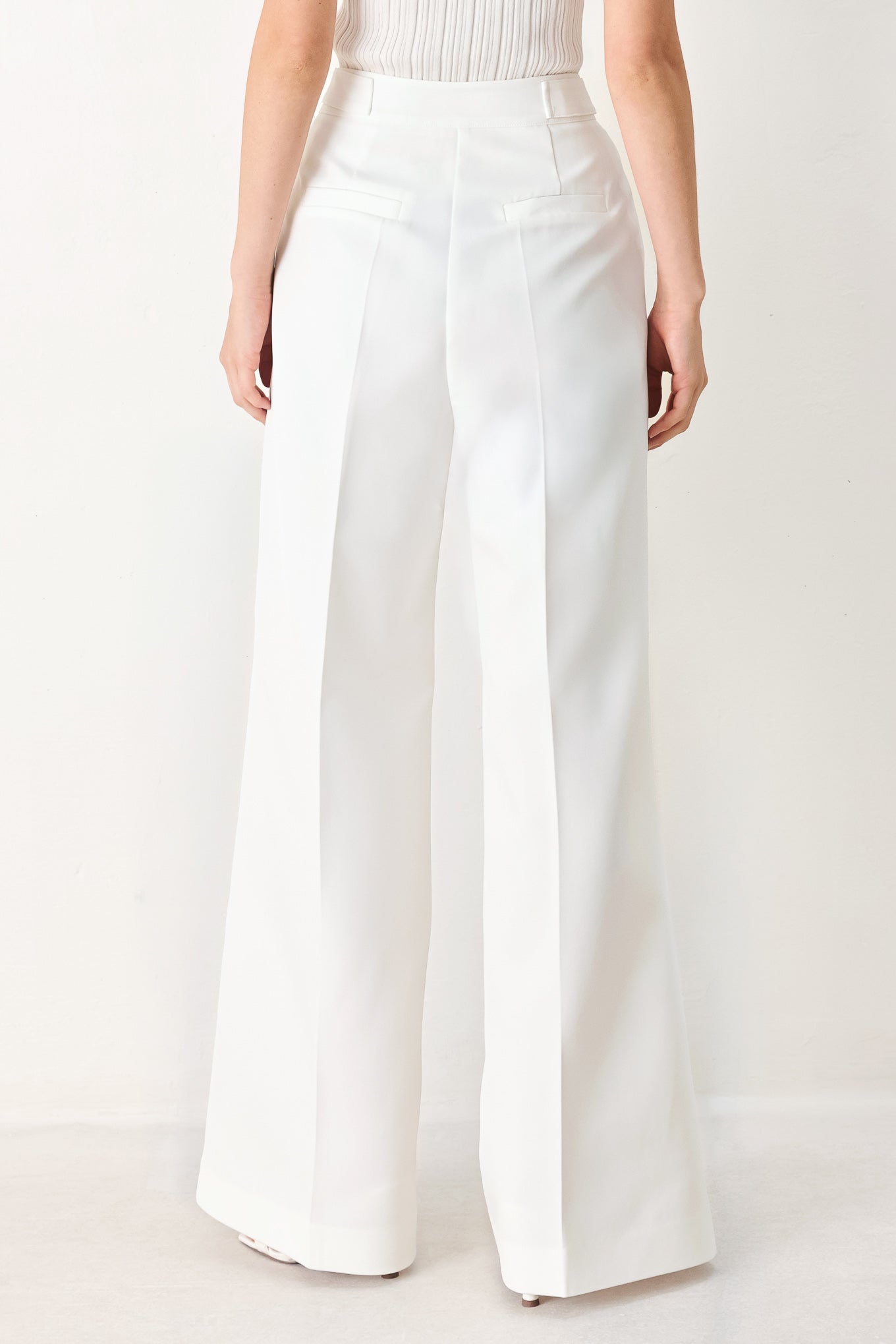 Woman wearing white wide-leg pants with side pockets and front closure | FREEMARKET