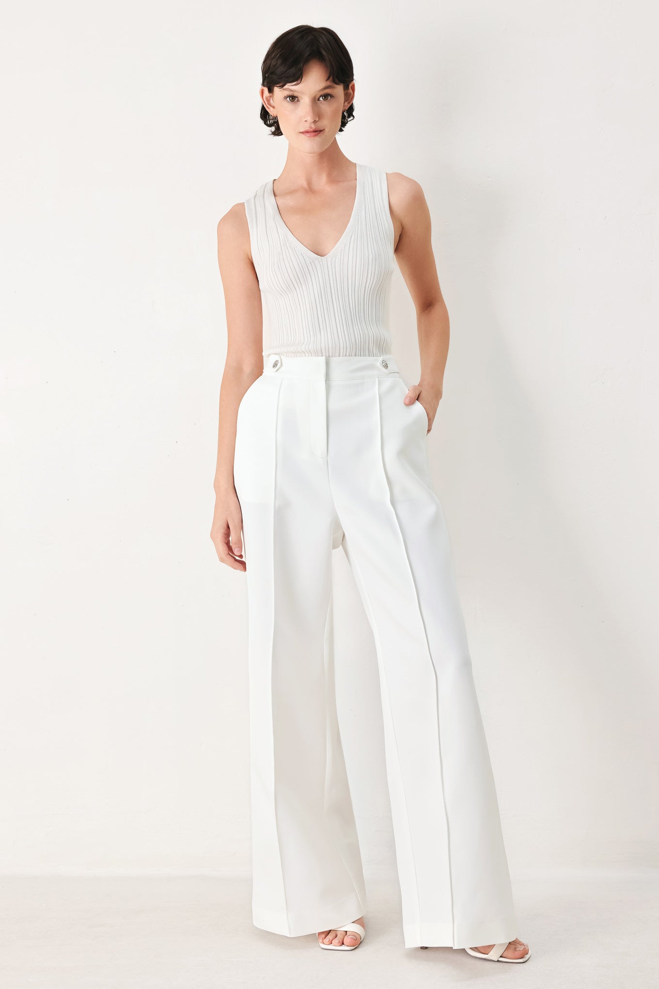Woman wearing white wide-leg pants with side pockets and front closure | FREEMARKET