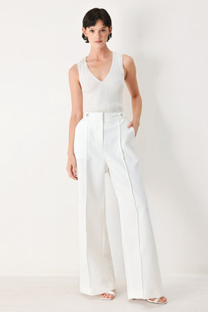 Woman wearing white wide-leg pants with side pockets and front closure | FREEMARKET