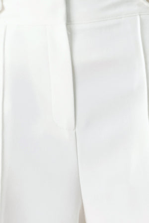 Woman wearing white wide-leg pants with side pockets and front closure | FREEMARKET