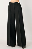Woman wearing black wide-leg solid woven pants with front closure and button on the side of the waist line | FREEMARKET