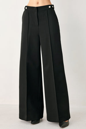 Woman wearing black wide-leg solid woven pants with front closure and button on the side of the waist line | FREEMARKET