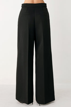 Woman wearing black wide-leg solid woven pants with front closure and button on the side of the waist line | FREEMARKET