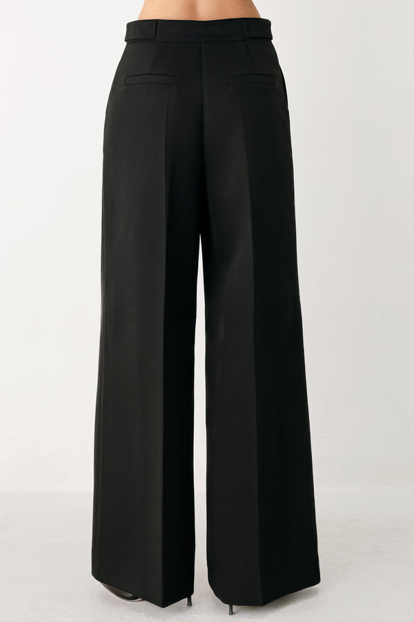 Woman wearing black wide-leg solid woven pants with front closure and button on the side of the waist line | FREEMARKET