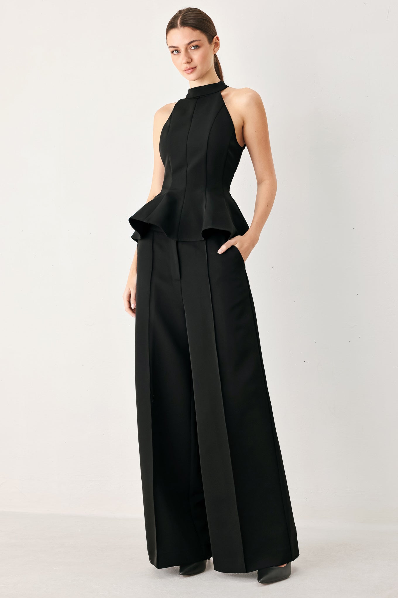 Woman wearing black wide-leg solid woven pants with front closure and button on the side of the waist line | FREEMARKET
