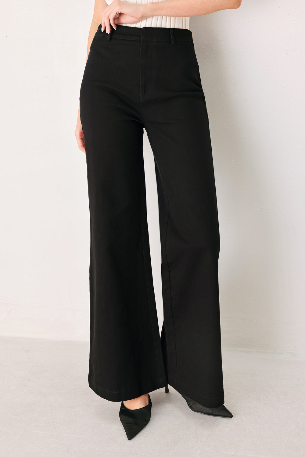Woman wearing a pair of high waisted black denim flared jeans | FREEMARKET