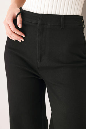Woman wearing a pair of high waisted black denim flared jeans | FREEMARKET