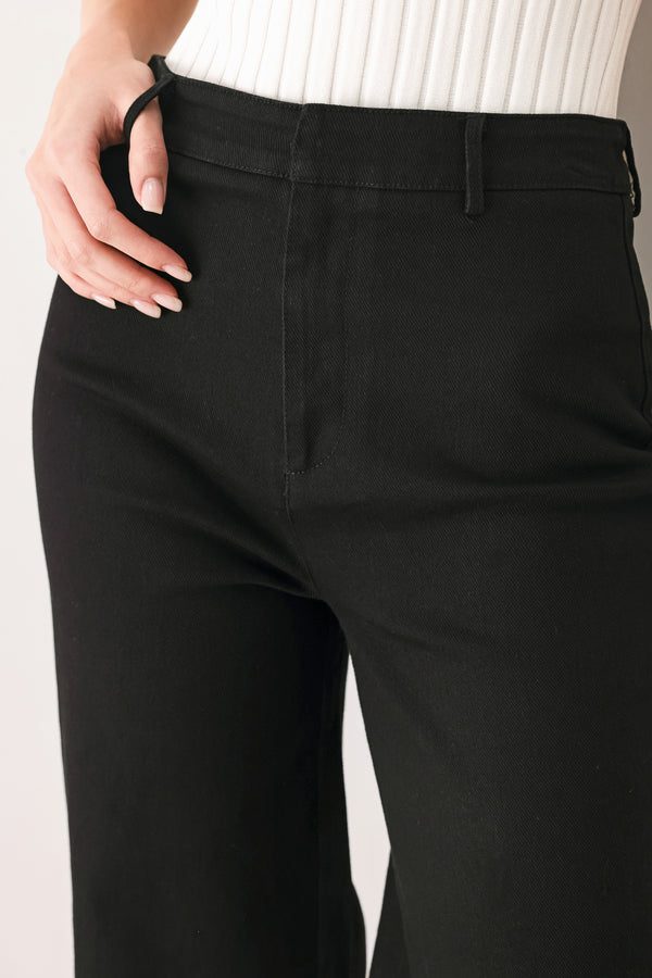 Woman wearing a pair of high waisted black denim flared jeans | FREEMARKET