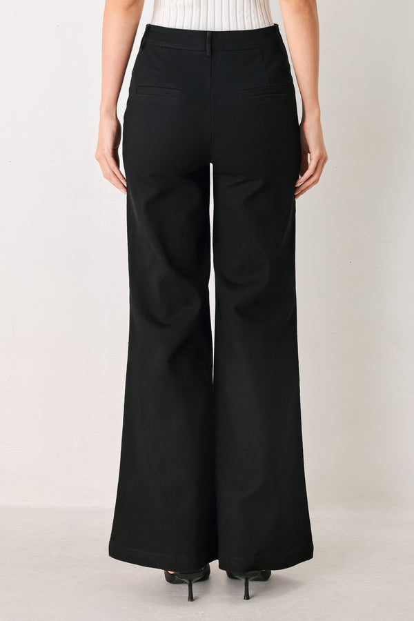 Woman wearing a pair of high waisted black denim flared jeans | FREEMARKET